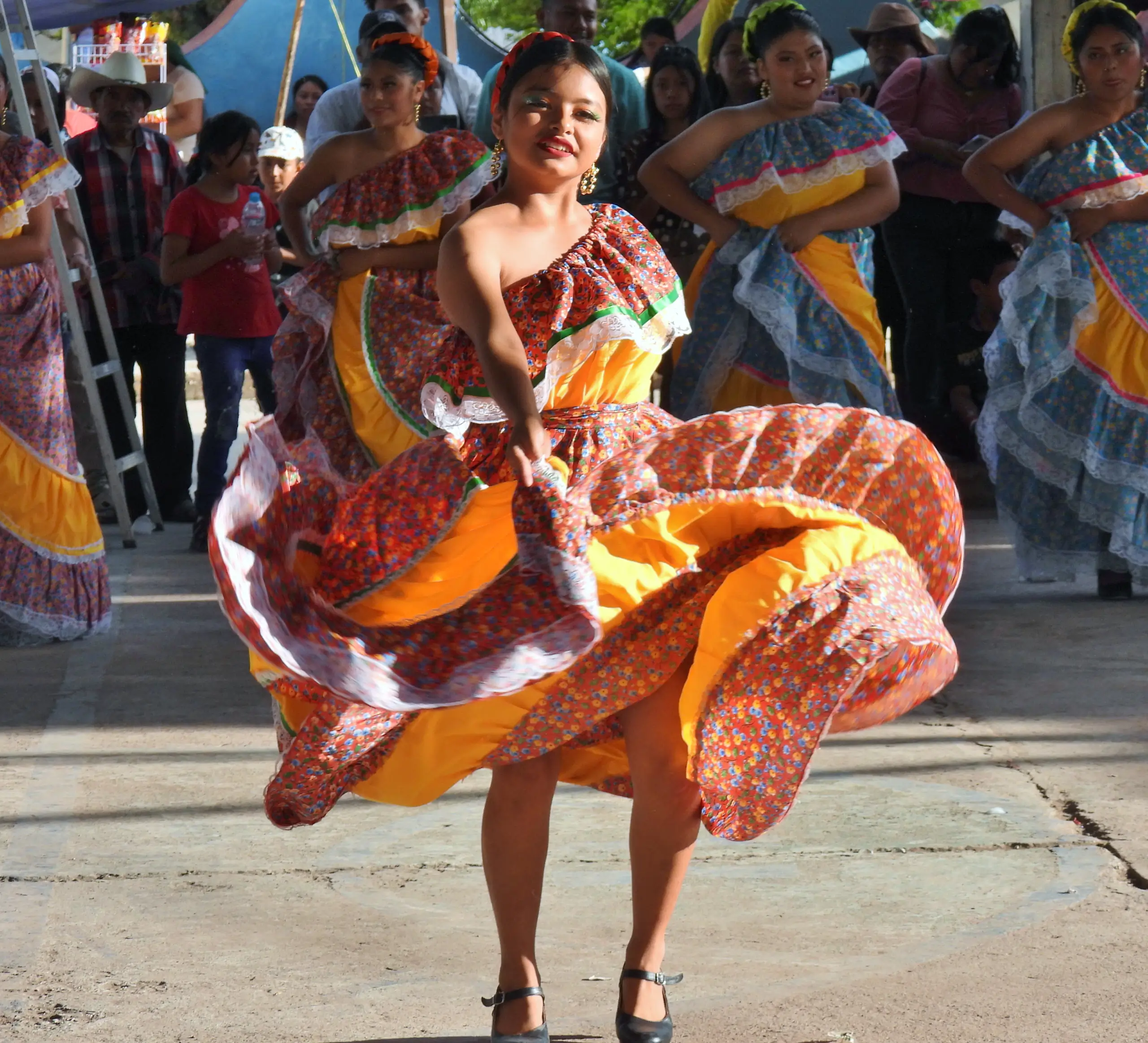 Bailarina con falda naranja amplia girando en un festival