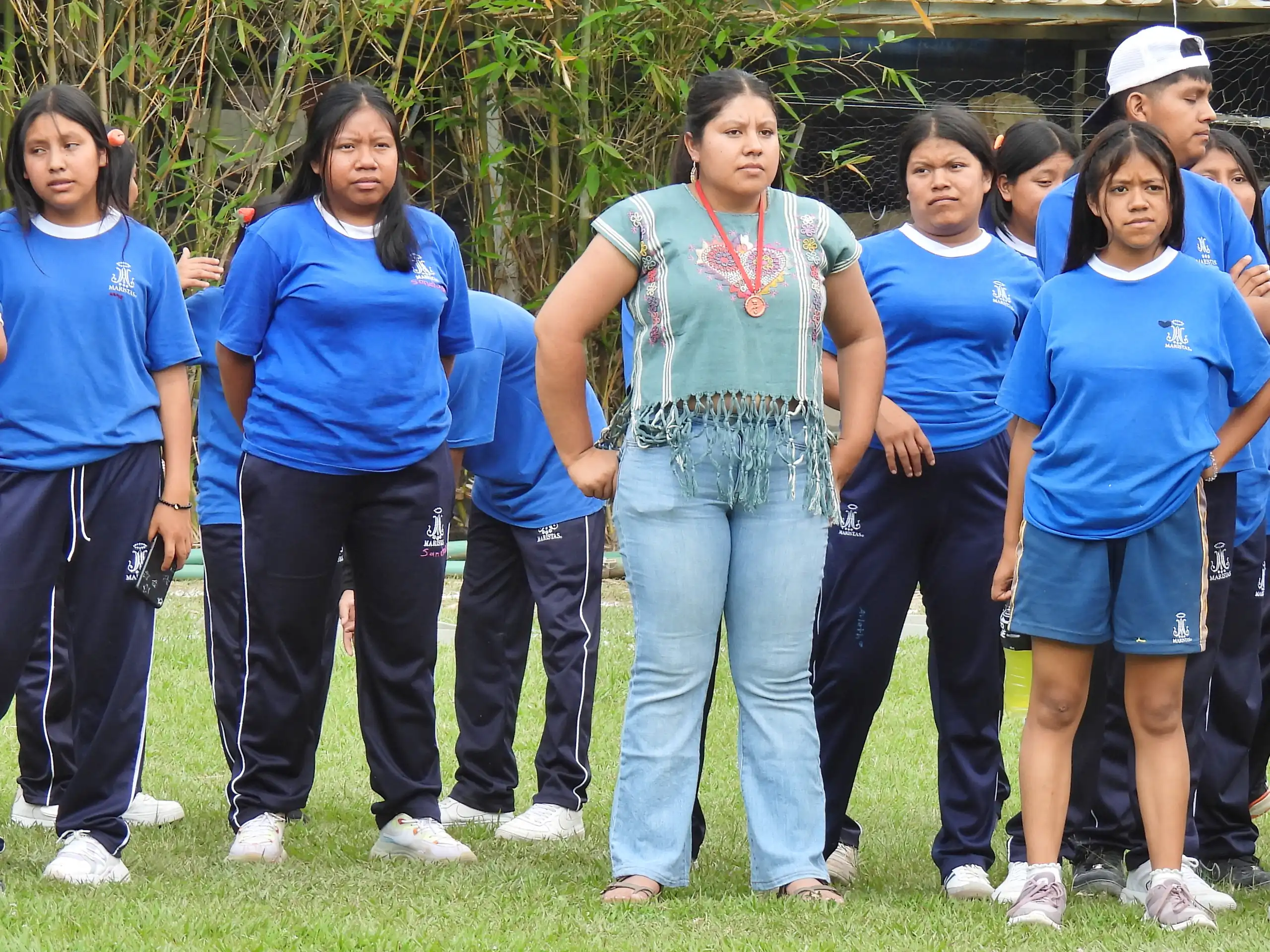 Grupo con playera azul formado sobre el pasto