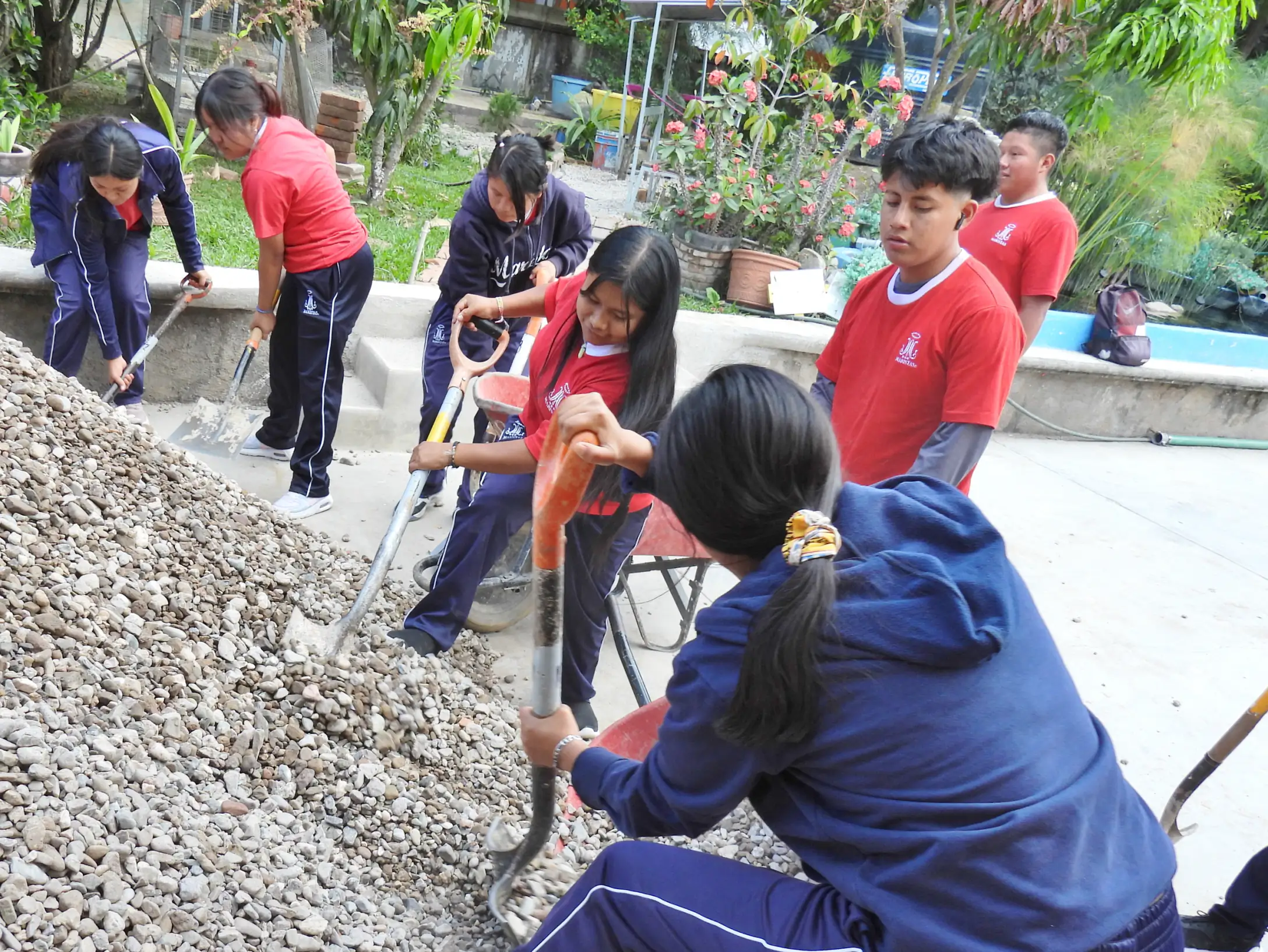 Alumnos moviendo grava con palas