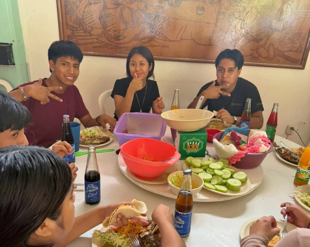 Estudiantes compartiendo la comida alrededor de una mesa